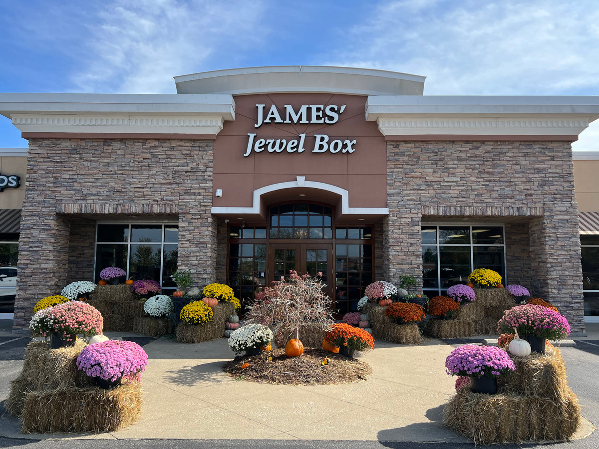 The James’ Jewel Box storefront with autumn flowers and pumpkins.